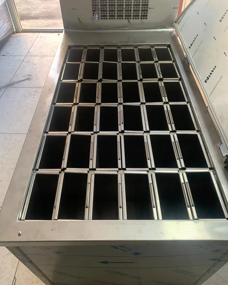 Machine à glace en bloc couvercle ouvert, rangées de moules en inox