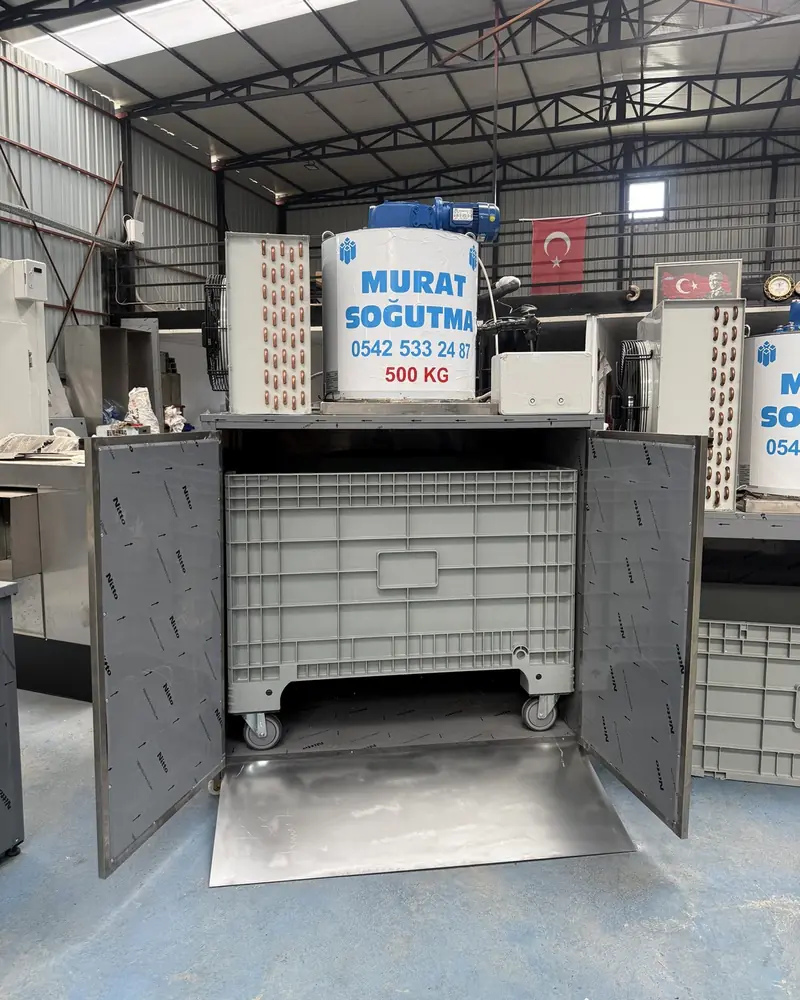 Machine à glace en écailles portes ouvertes, bac à roulettes à l'intérieur